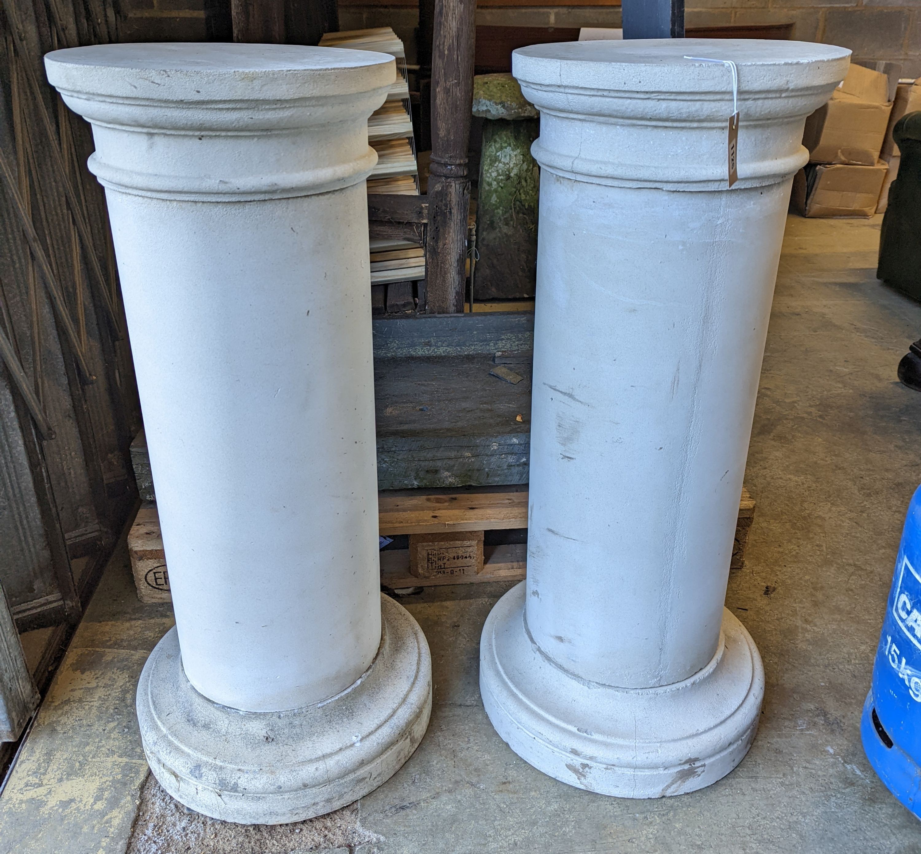 A pair of circular stone pedestals, tops 38cm diameter, height 99cm